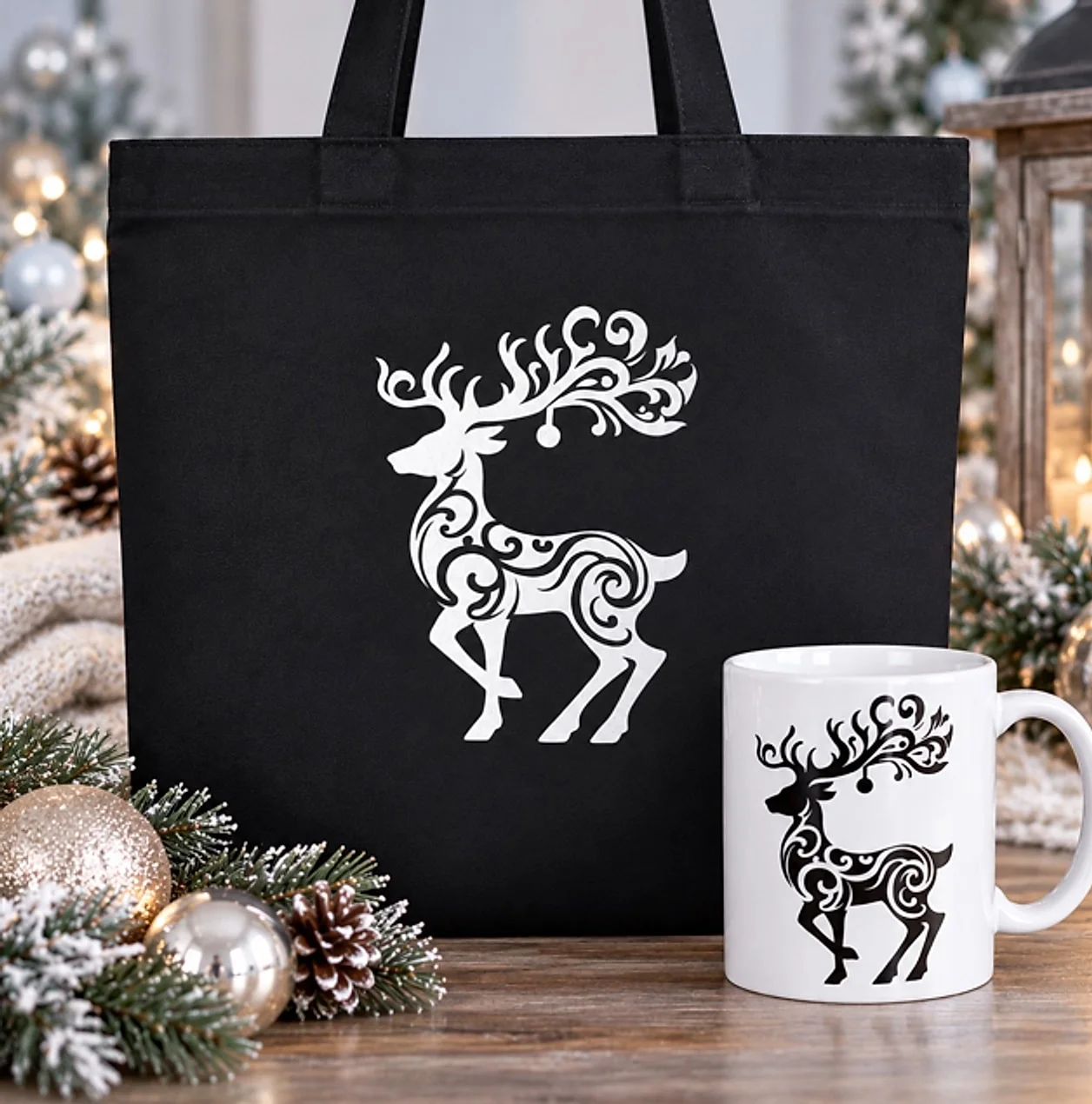 Black tote and white mug with a matching swirled reindeer design among holiday pinecones and ornaments